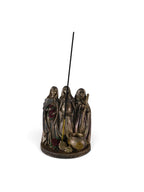 The Witches' Quest bronze-toned Triple Goddess incense holder featuring Maiden, Mother, and Crone figures with a cauldron