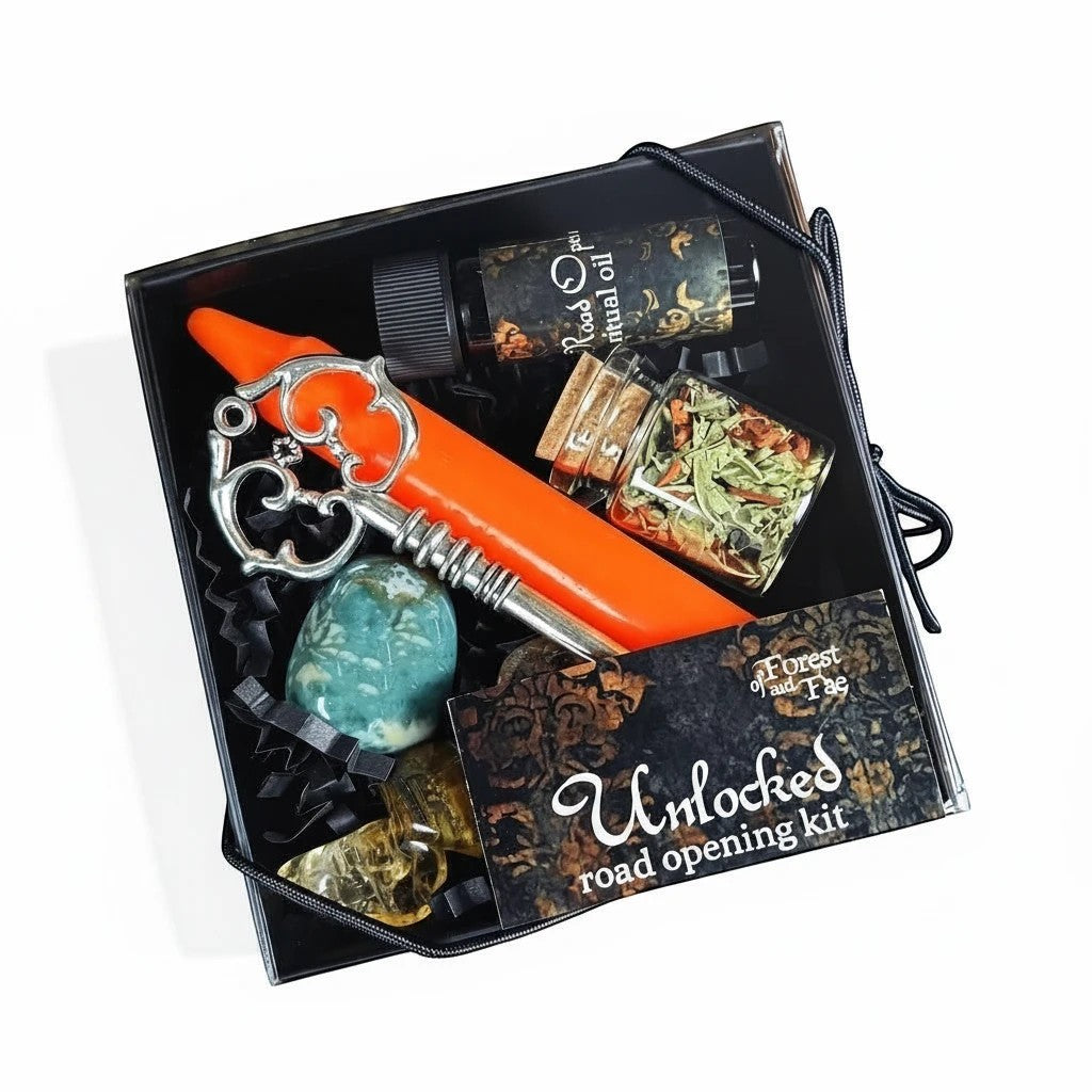 The Witches' Quest Unlocked Spell Kit for road opening featuring an orange candle, skeleton key, oil, and crystals.